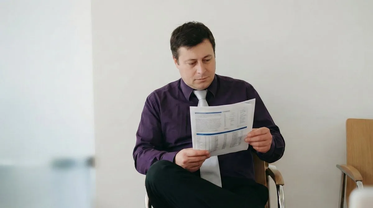Laurent Tulpan reading a printed technical report (illustration generated from his portrait)