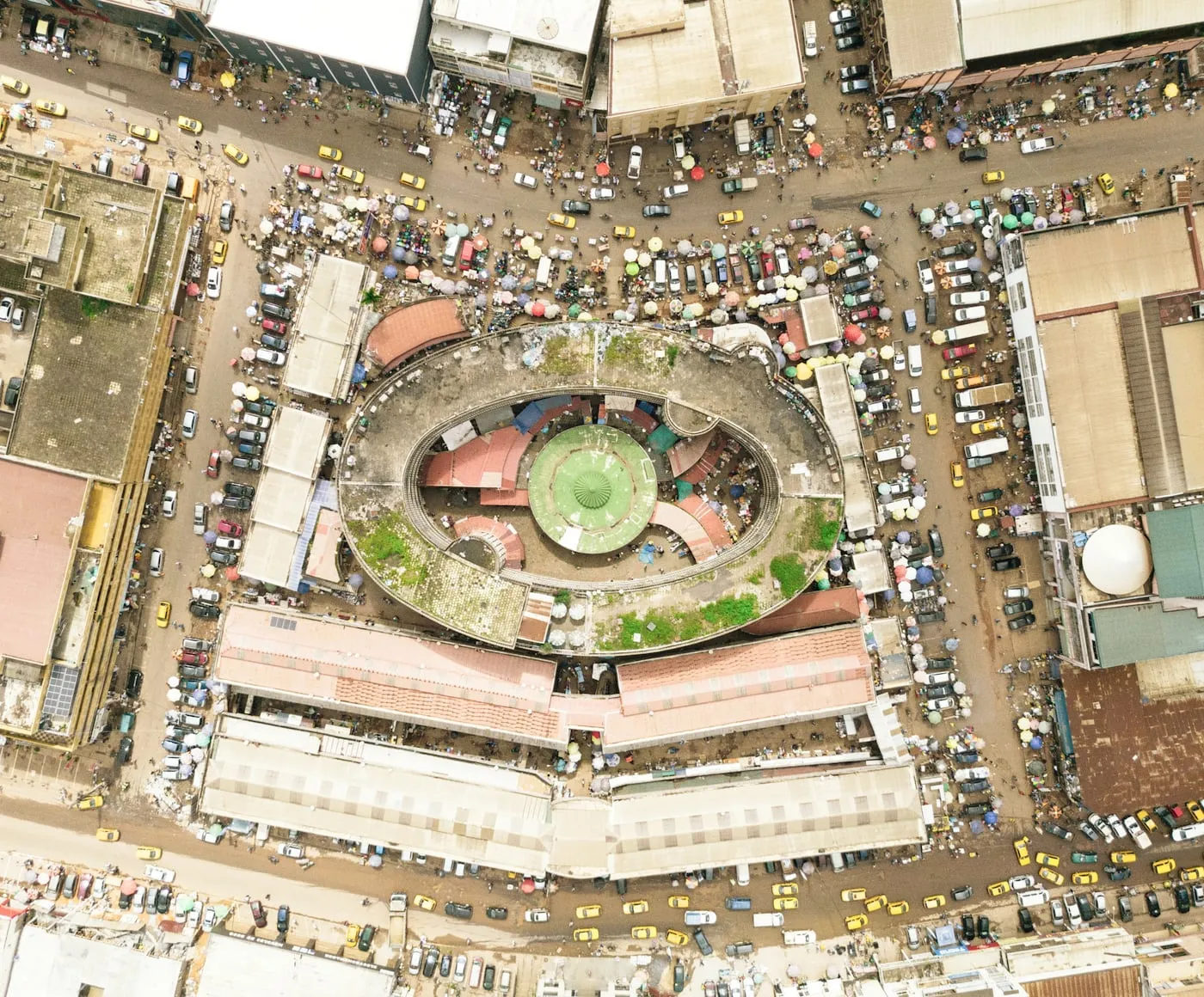Yaoundé vue du ciel : un marché circulaire, les rues et les toits autour, la ville que la base d'adressage décrit